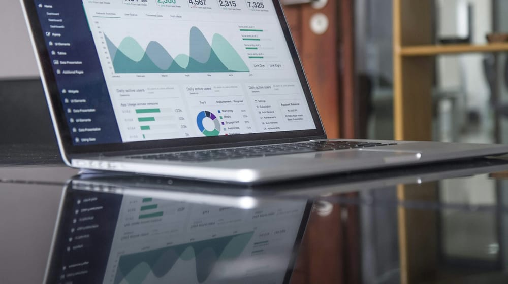 Laptop on a glass desk showing analytics charts used to track Next.js search performance