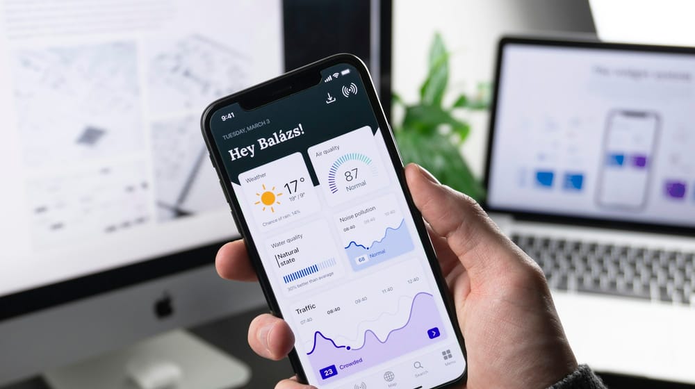 Hand holding a phone showing a dashboard app with smooth, app-like screen transitions