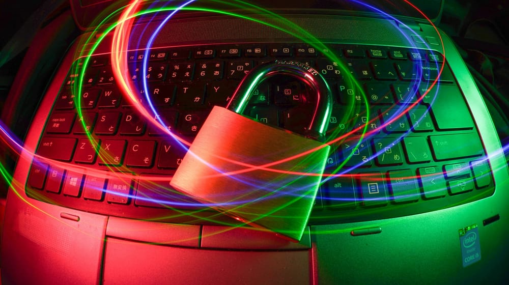 Padlock resting on a laptop surrounded by colourful light trails, symbolising website security