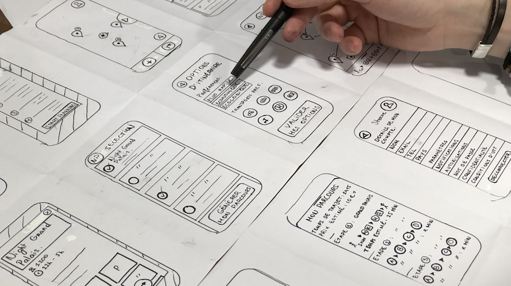 Hand sketching website layout ideas on paper